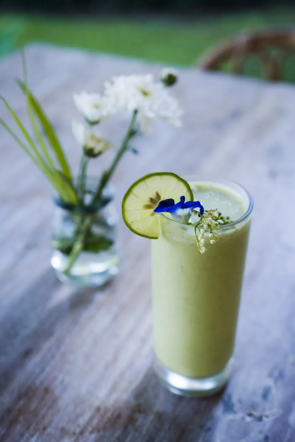A herbal infusion served in a glass with a blue flower garnish
