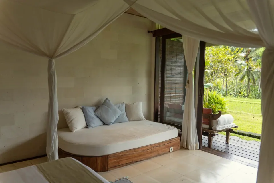 A cushioned daybed beside an open garden terrace