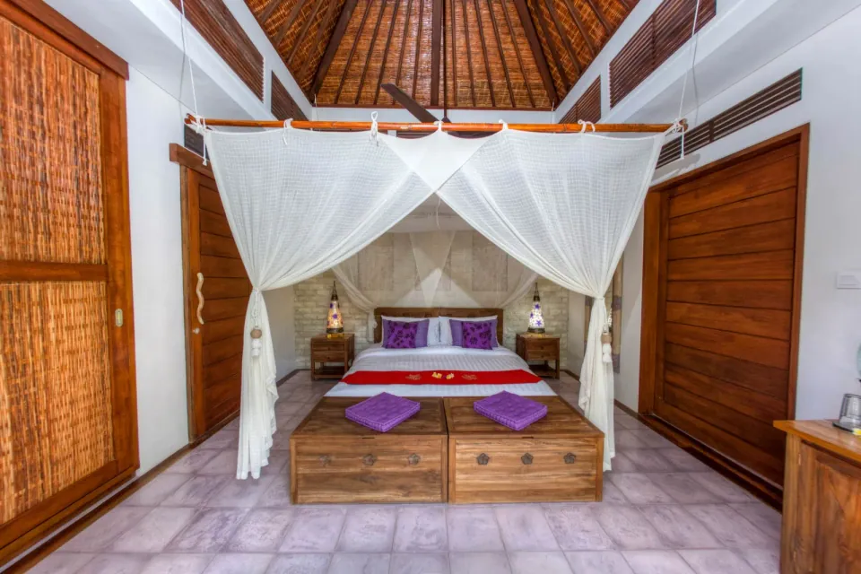 A wooden bedroom with a canopy bed and carved doors
